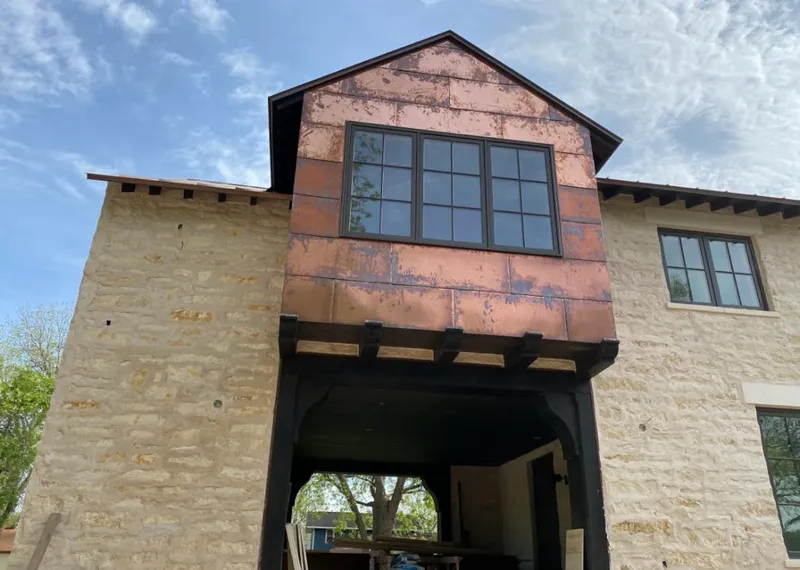 Copper metal panel facade on a stone building for Skylight Installation in Rib Mountain